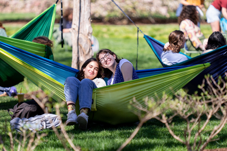 Students sitting and smiling in hammocks.